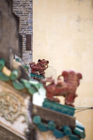 Zwei handwerkliche Steinlöwen, die sich auf dem Dach eines klassischen chinesischen Gebäudes anschauen