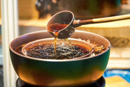 Traditional Chinese copper pot is cooking Pu'er tea, making tea around the stove