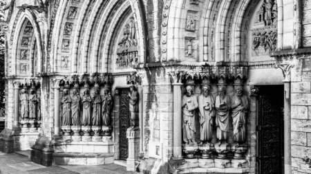 Téléchargez les photos : Détails de la façade de la cathédrale Sainte Fin Barre à Cork, Irlande. Sculptures de figures religieuses à l'entrée de l'église. monochrome. - en image libre de droit