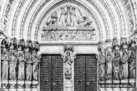 Foto de La entrada a la catedral anglicana de St Fin Barre 's en la ciudad irlandesa de Cork. Esculturas de las cinco vírgenes sabias y cinco vírgenes tontas a ambos lados de las puertas de la iglesia. Estilo neogótico. Monocromo - Imagen libre de derechos