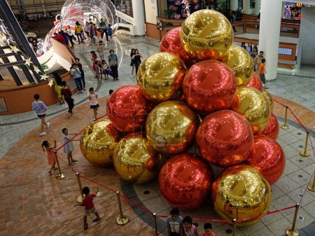 Téléchargez les photos : Siem Reap, Cambodge, 23 décembre 2018. D'énormes boules décoratives festives dans un centre commercial cambodgien, des gens dans un lieu public. - en image libre de droit