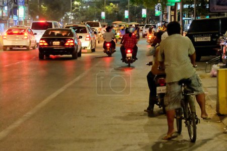 Foto de Siem Reap, Camboya, 23 de diciembre de 2018. Imagen que captura la bulliciosa escena del tráfico en una calle de la ciudad asiática durante la noche, con coches y motocicletas. - Imagen libre de derechos