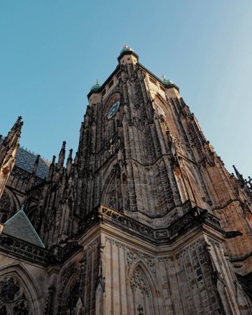 Photo for A Gothic cathedral with two towers and a clock face against a blue sky. The medieval gothic St. Vitus Cathedral in Prague. - Royalty Free Image