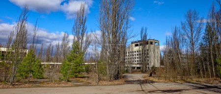 Photo for An abandoned structure under a blue sky with scattered clouds. The Polissya hotel is one of the tallest buildings in the abandoned city of Pripyat, Ukraine, Chernobyl. - Royalty Free Image