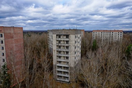 Téléchargez les photos : Des gratte-ciel en décomposition au milieu de la végétation sauvage, une scène de décomposition urbaine. - en image libre de droit