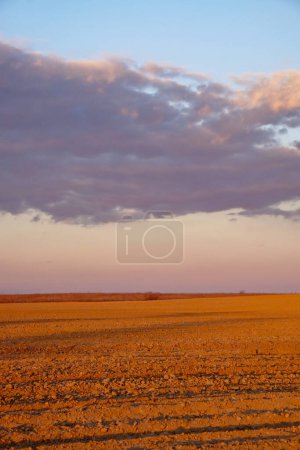 The image captures rocks on ground with clouds in the distant sky.