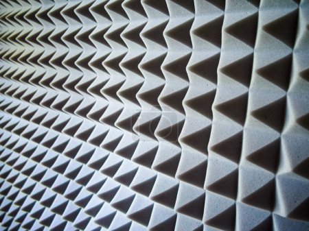 Acoustic Foam Panels. Grey pyramid-patterned panels for soundproofing and noise reduction.
