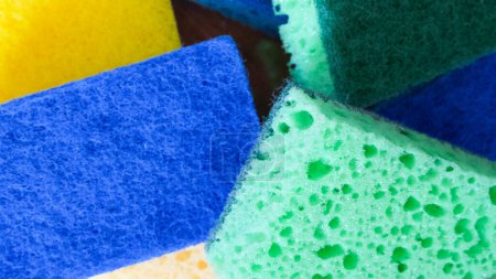 Téléchargez les photos : Aides de nettoyage colorées. Une pile d'éponges bleues, vertes et jaunes. Utilisations pour les catalogues de produits de nettoyage, guides de ménage. - en image libre de droit