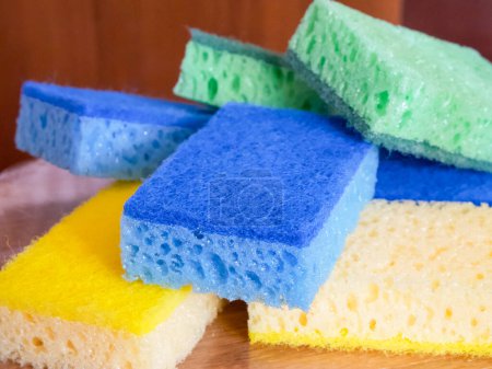 Téléchargez les photos : Éponges nettoyantes vibrantes. Une pile d'éponges bleues, jaunes et vertes. Utilisations pour les annonces de produits de nettoyage, blogs de ménages. - en image libre de droit