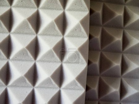 Espuma de absorción de sonido. Primer plano de los paneles acústicos grises con textura piramidal.