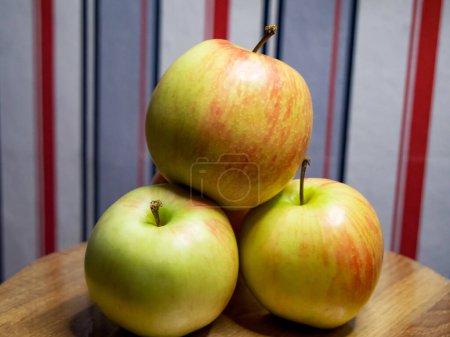 Vibrant Apple Assortment. A collection of apples with varying red and green shades on a wooden surface, ideal for health and nutrition themes.