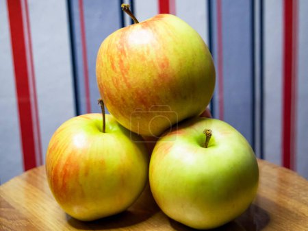 Frische Äpfel. Äpfel mit einem Farbmix auf Holz präsentiert, perfekt für lebensmittelbezogenes Marketing und Bildungsinhalte.