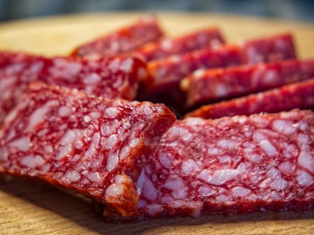 Eine Nahaufnahme von geschnittener Salami mit marmoriertem Fett und magerem Fleisch, ideal für kulinarische Themen.