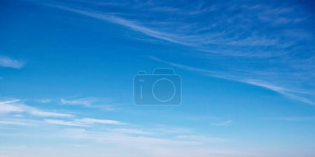 Un cielo azul sereno con nubes tenues, sugiriendo calma, ideal para fondos o visuales de meditación. Cielo azul expansivo con rayas de nubes delicadas, evocando tranquilidad.