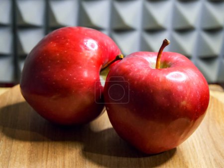 Fresh Apples on Wood. Two red apples with stems on a wooden surface, bright and clear.