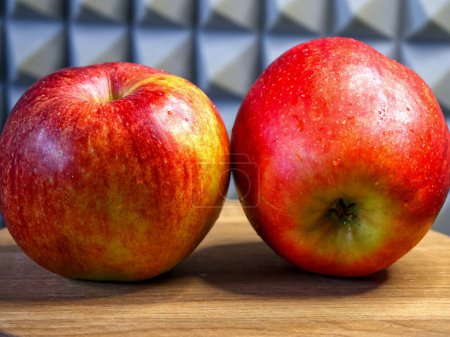 Apples and Art. Red apples against a detailed backdrop, placed on wood, for grocery ads.