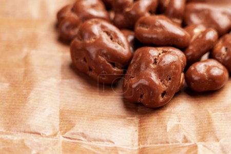 Glazed chocolate nut candies. Whole walnut dragee