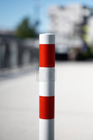 Photo for White red barrier post in front of path and bridge with buildings in blurred background - Royalty Free Image