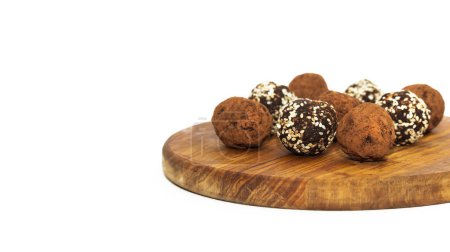 Energy balls in white bowl. Healthy raw dessert, vegetarian truffles, sugar free candies made of dates, hazelnuts, cocoa powder.