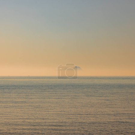 Photo for Ponza, Italy. The silhouette of the island emerging from the fog, seen from the Lazio coast in the distance. - Royalty Free Image