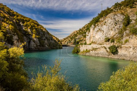 Lake San Domenico, in the Sagittario Gorges, in Abruzzo, L'Aquila, Italy. The small hermitage with the stone bridge. The turquoise color of the water. The glow of the sun, flare at sunset.