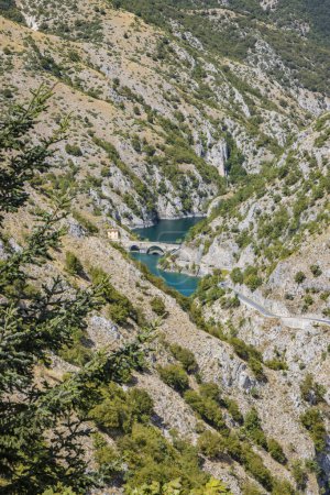 Der San Domenico-See in den Sagittario-Schluchten in den Abruzzen, L 'Aquila, Italien. Die kleine Einsiedelei mit der Steinbrücke. Die grünen Berge und die türkisfarbene Farbe des Wassers.