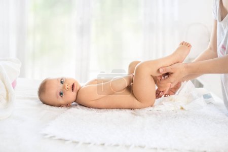 Kleines Baby liegt beim Windelwechsel im Bett, Neugeborenes Windelkonzept