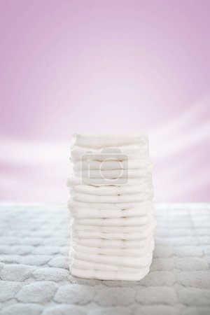 Foto de Pila de pañales blancos y suaves para bebés en el cambiador - Imagen libre de derechos
