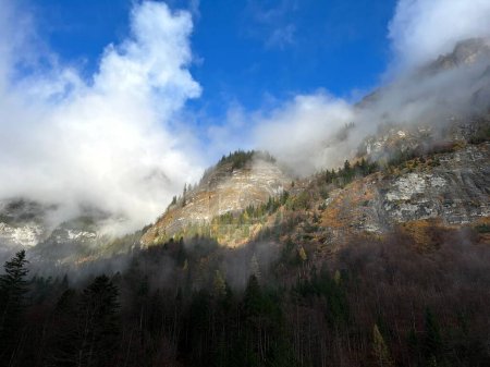 Photo for Mystical low autumn clouds and typical mountain fog in Swiss alpine area over the Taminatal river valley, Vaettis - Canton of St. Gallen, Switzerland (Kanton St. Gallen, Schweiz) - Royalty Free Image