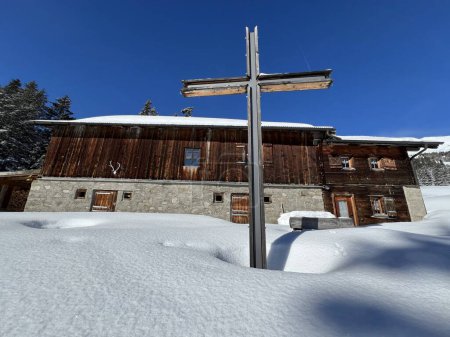 Christian crucifix in the magical winter setting of the Swiss Alps and on the snow-covered alpine pastures the tourist resorts of Valbella and Lenzerheide - Canton of Grisons, Switzerland (Kanton Graubuenden, Schweiz)