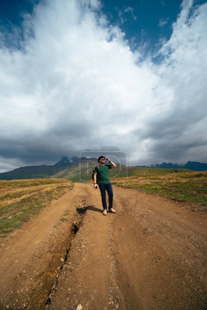 Téléchargez les photos : Homme randonnée aux lacs Koruldi, belle vue sur les montagnes du Grand Caucase près de Mestia en Haute-Svaneti, Géorgie. Photo verticale. Jour d'été - en image libre de droit