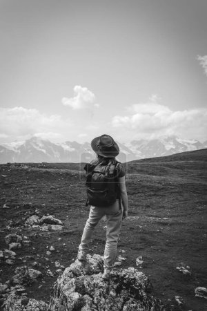 Foto de Una mujer, un turista, un viajero está parado sobre una roca. Destino. Blanco y negro. ruta a los lagos Koruldi, región de Svaneti, Georgia. Día de verano en las montañas del Cáucaso. Foto vertical - Imagen libre de derechos