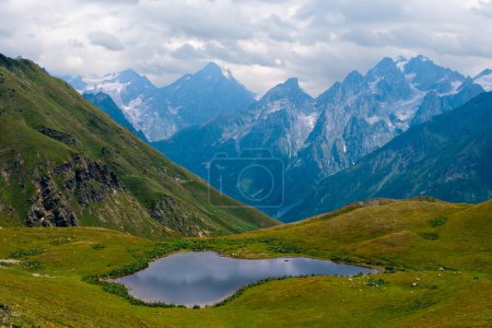 Téléchargez les photos : Lacs Koruldi dans les montagnes du Caucase, Mestia, région de Svaneti, Géorgie. Journée d'été, collines verdoyantes, pâturages de haute montagne pour le bétail, sommets enneigés. Grand panorama à haute résolution - en image libre de droit