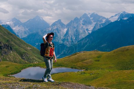 Photo for A woman at the Koruldi Lake with an amazing view on mountain ridges near Mestia in the Caucasus Mountain Range, Upper Svaneti, Country of Georgia. Wanderlust. Trekking. Copy space - Royalty Free Image