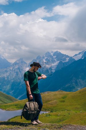 Téléchargez les photos : Un voyageur près du lac Koruldi, Mestia dans la chaîne de montagnes du Grand Caucase Upper Svaneti, Géorgie. Faune, voyage et vacances. Jour d'été. Photo verticale - en image libre de droit