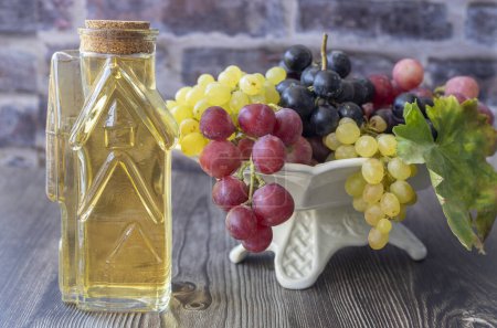 Foto de Vinagre de uva en botella, fondo de madera oscura, enfoque selectivo - Imagen libre de derechos