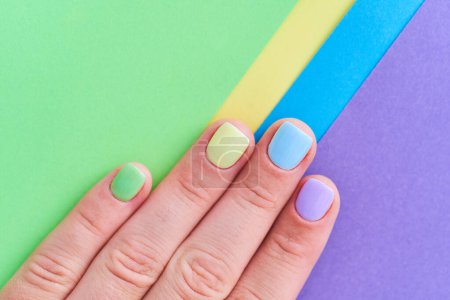 Foto de Dedos femeninos con uñas de colores brillantes sobre un fondo colorido de cerca. Vista superior - Imagen libre de derechos