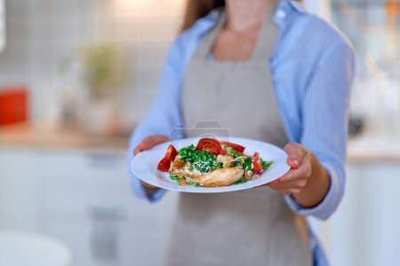 Foto de Mujer cocinera con un plato de ensalada César fresca - Imagen libre de derechos