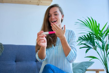 Photo for Young happy satisfied shocked surprised woman rejoices to a positive pregnancy test - Royalty Free Image