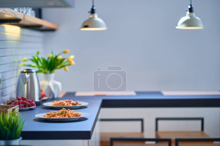 Téléchargez les photos : Table noire avec assiettes à plat dans la cuisine moderne de style loft - en image libre de droit
