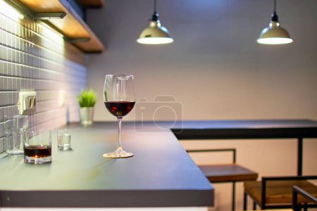Foto de Copa de vino tinto de pie sobre una mesa en una cocina estilo loft - Imagen libre de derechos