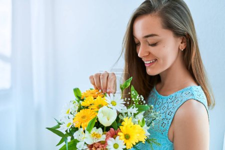 Téléchargez les photos : Belle jeune femme souriante heureuse avec décoratif coloré lumineux chapeau de fleur fraîche boîte à vacances printemps jour des femmes - en image libre de droit
