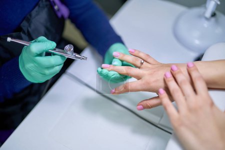 Photo for Woman in nails salon receiving gel polish manicure by manicurist master. Gentle care treatment of nails - Royalty Free Image