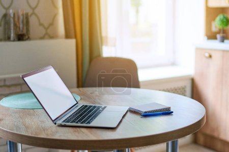 Foto de Abra la computadora portátil con pantalla blanca en blanco en la mesa en el espacio de trabajo. Maqueta de ordenador para la publicidad en línea del sitio web - Imagen libre de derechos