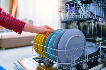 Foto de Ama de casa mujer usando lavavajillas moderno para lavar platos en la cocina casera - Imagen libre de derechos