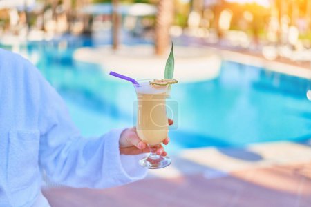 Téléchargez les photos : Relaxing summer vacations with refreshing pina colada cocktail by the pool at the all-inclusive resort - en image libre de droit
