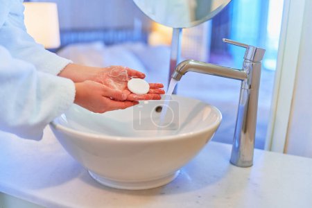 Téléchargez les photos : Female washing her hands in cozy bathroom - en image libre de droit