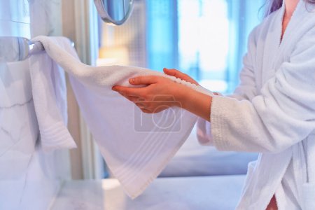 Téléchargez les photos : Woman drying her hands with white cotton soft towel in bathroom - en image libre de droit