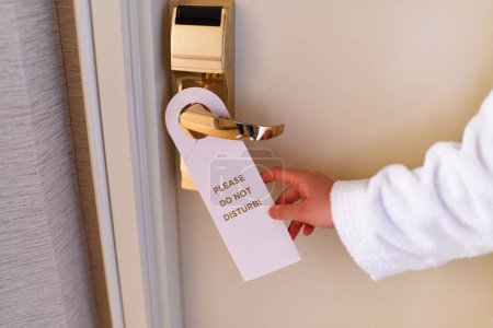 Téléchargez les photos : Do not disturb sign on the doorknob of hotel - en image libre de droit