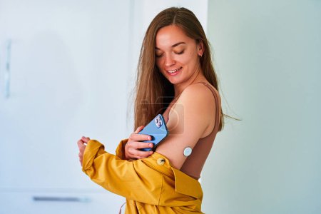 Photo for Diabetic patient control, monitoring and checking glucose level without blood with remote sensor and smartphone. Medical technology in diabetes treatment - Royalty Free Image